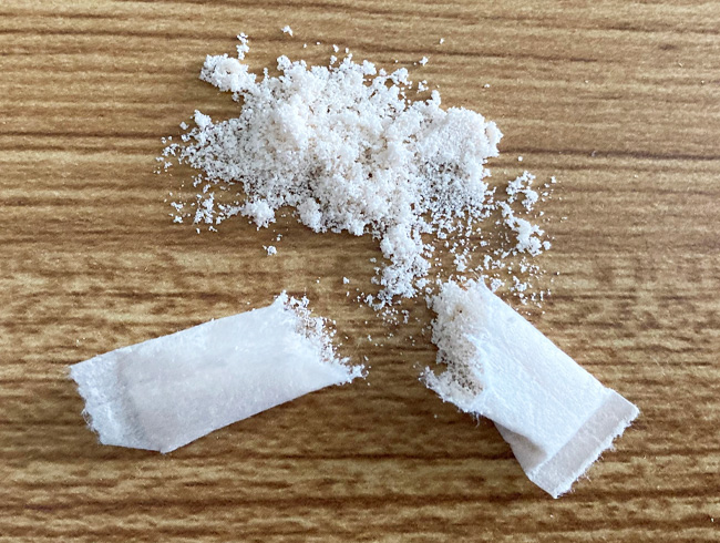 sacchettino bianco rotto e polvere sul tavolo